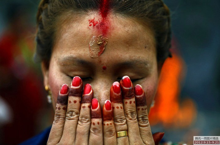 Một phụ nữ cầu nguyện trong lễ hội truyền thống Tiji ở Kathmandu, Nepal. Trong lễ hội này, phụ nữ có gia đình cầu nguyện cho chồng và hạnh phúc gia đình, còn các cô chưa lập gia đình thì cầu mong có được một tấm chồng